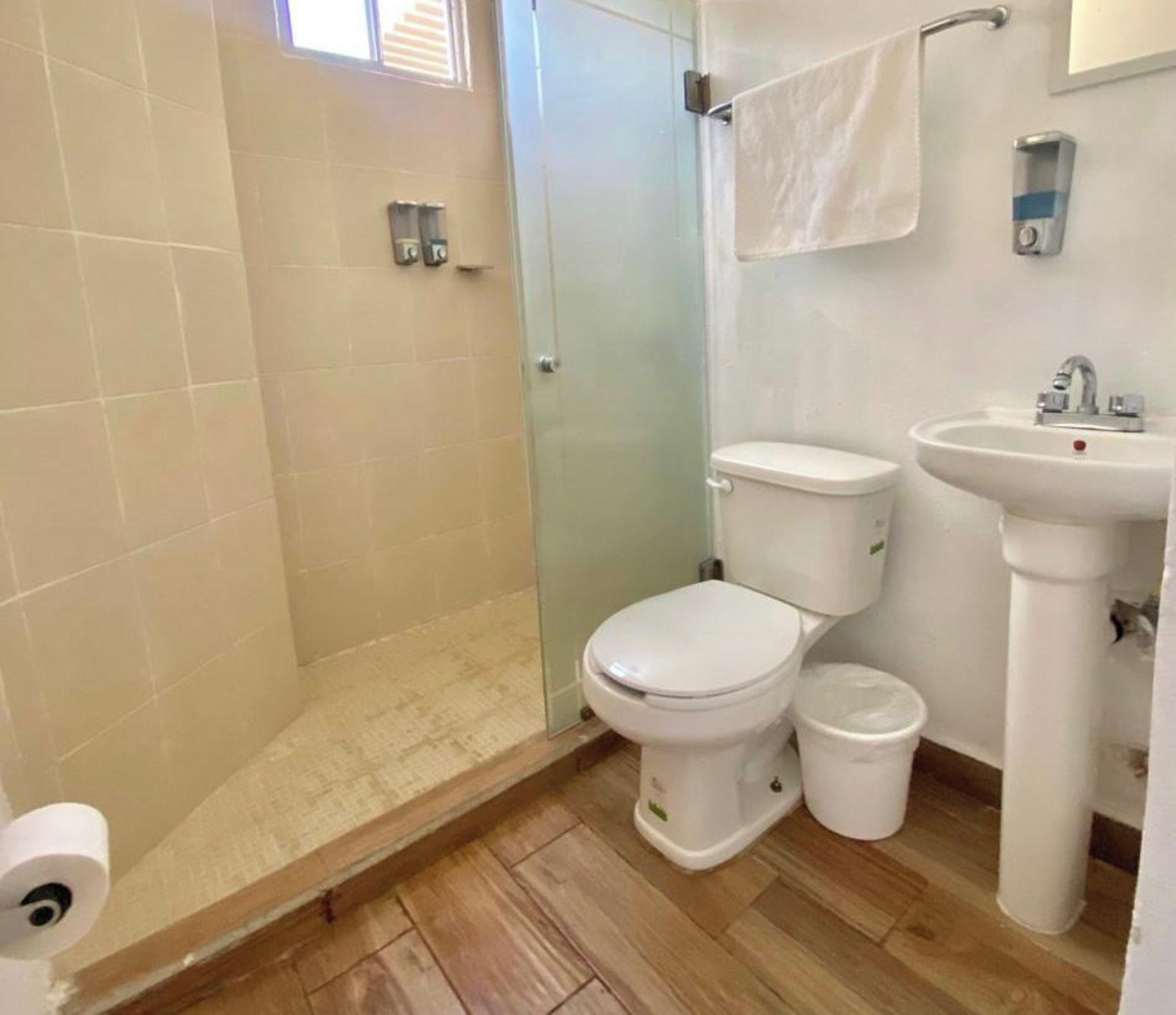 Een kleine badkamer met toilet, wastafel en douche.