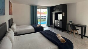 A hotel room with two beds, a desk, and a view of the pool. - Casa Balam Cancun (Cancun)