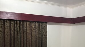 Una habitación de hotel con una cama, una toalla azul y una cortina.
