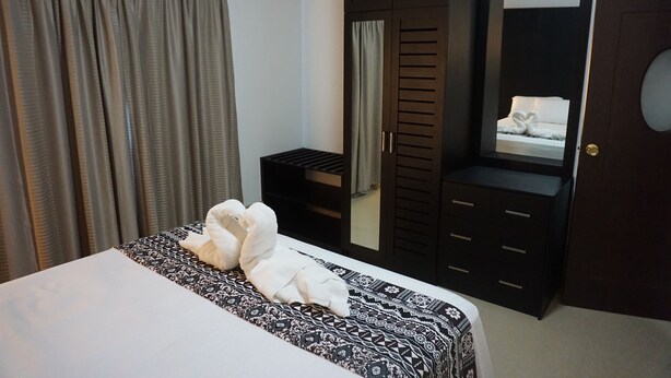 A hotel room with a bed, a wardrobe, and a mirror. - One Bedroom House HHK-19-1 (Lautoka)