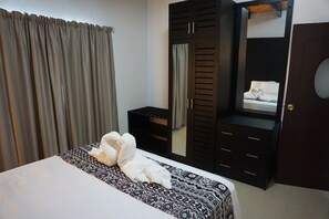 Une chambre d’hôtel avec un lit, une armoire et un miroir.