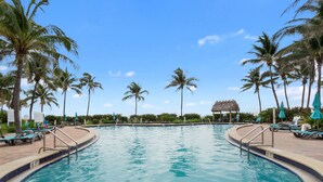 A swimming pool with a 6 ft depth marker, surrounded by lounge chairs and palm trees. - 15K on the Ocean with Lateral Ocean Views (Hollywood)