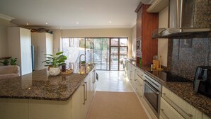 Una cocina moderna con encimeras de granito, electrodomésticos de acero inoxidable y una isla grande.
