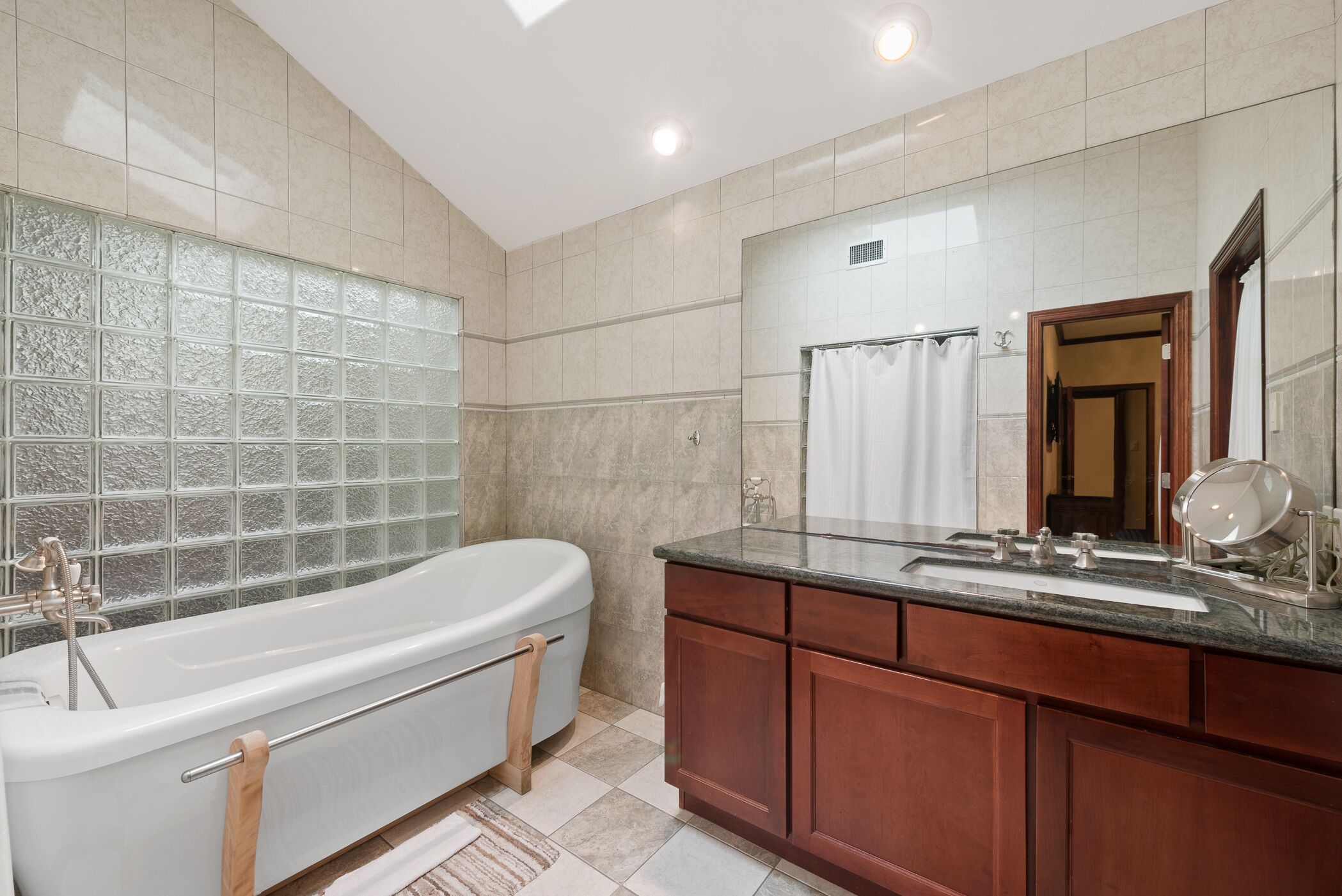 A modern bathroom with a freestanding bathtub, a vanity with a mirror, and a glass shower enclosure.