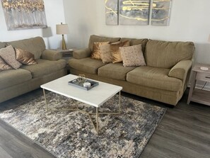 Una sala de estar con dos sofás, una mesa de centro y una alfombra.