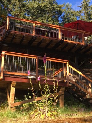 Stunning multi-level structure with balconies and staircases, offering panoramic views of the surrounding trees and foliage.