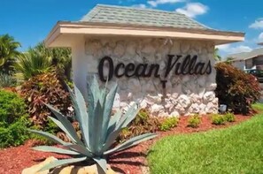 Ocean Villas offers a serene setting with a stone facade and lush green surroundings.