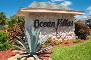 Ocean Villas offers a serene setting with a stone facade and lush green surroundings.