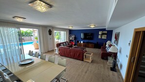 A spacious living area with a dining table, sofas, and a TV. - Detached Villa with Private Pool, close to all amenities and a blue flag beach (Santiago del Teide)