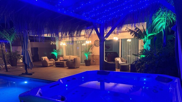A hot tub area with a pool, lounge chairs, and potted plants. - Detached Villa with Private Pool, close to all amenities and a blue flag beach (Santiago del Teide)