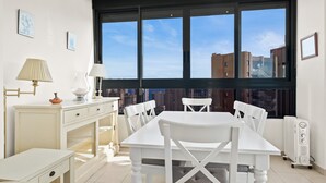 A bright room with a large window, white furniture, and a radiator.