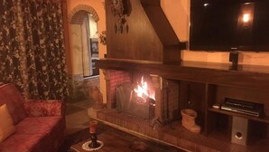A cozy living room with a fireplace, a sofa, and a television. - Tuscan rustic villa with pool, wifi, outdoor jacuzzi, (Pieve al Toppo)