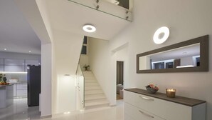 Un interior moderno con una escalera, una zona de cocina y un tocador con espejo.