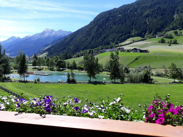 A scenic view of a lake surrounded by mountains, with a wooden deck in the foreground and a clear sky. - Top 1 or 2 incl. STUBAI SUPER SUMMER CARD (Neustift im Stubaital)