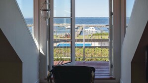 Ein Zimmer mit großem Fenster und Blick auf eine Marina mit Booten sowie einen Poolbereich.