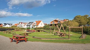 Ein Park mit Picknicktischen und Holzspielgeräten.