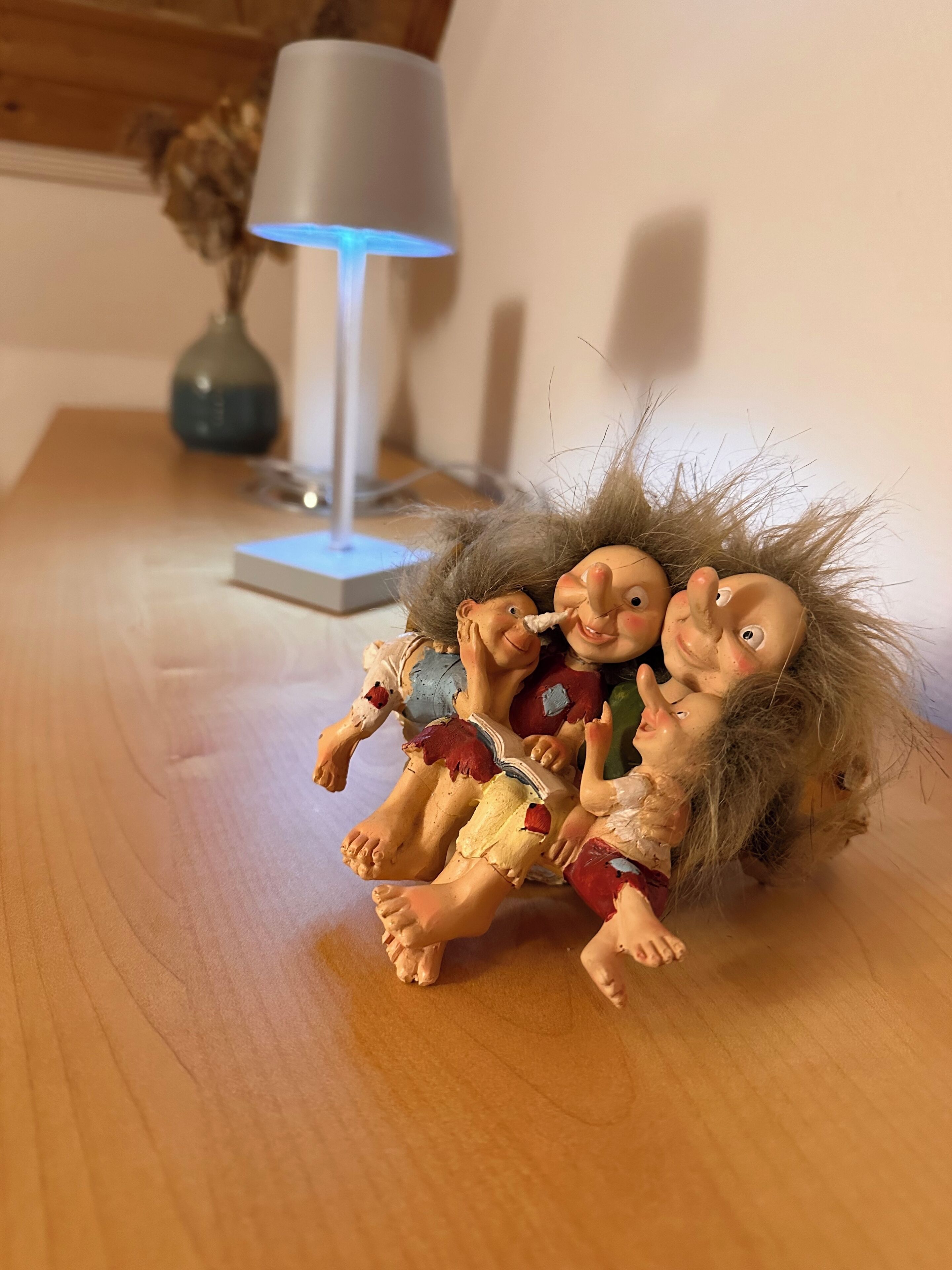 A doll with a braided hair accessory on a wooden surface.