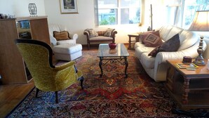 A living room with a patterned carpet, two sofas, a coffee table, and a lamp. - Comfy Safe Quiet Haven, Dog Friendly!  2 Miles to Downtown or to Vilano Beach (St. Augustine)
