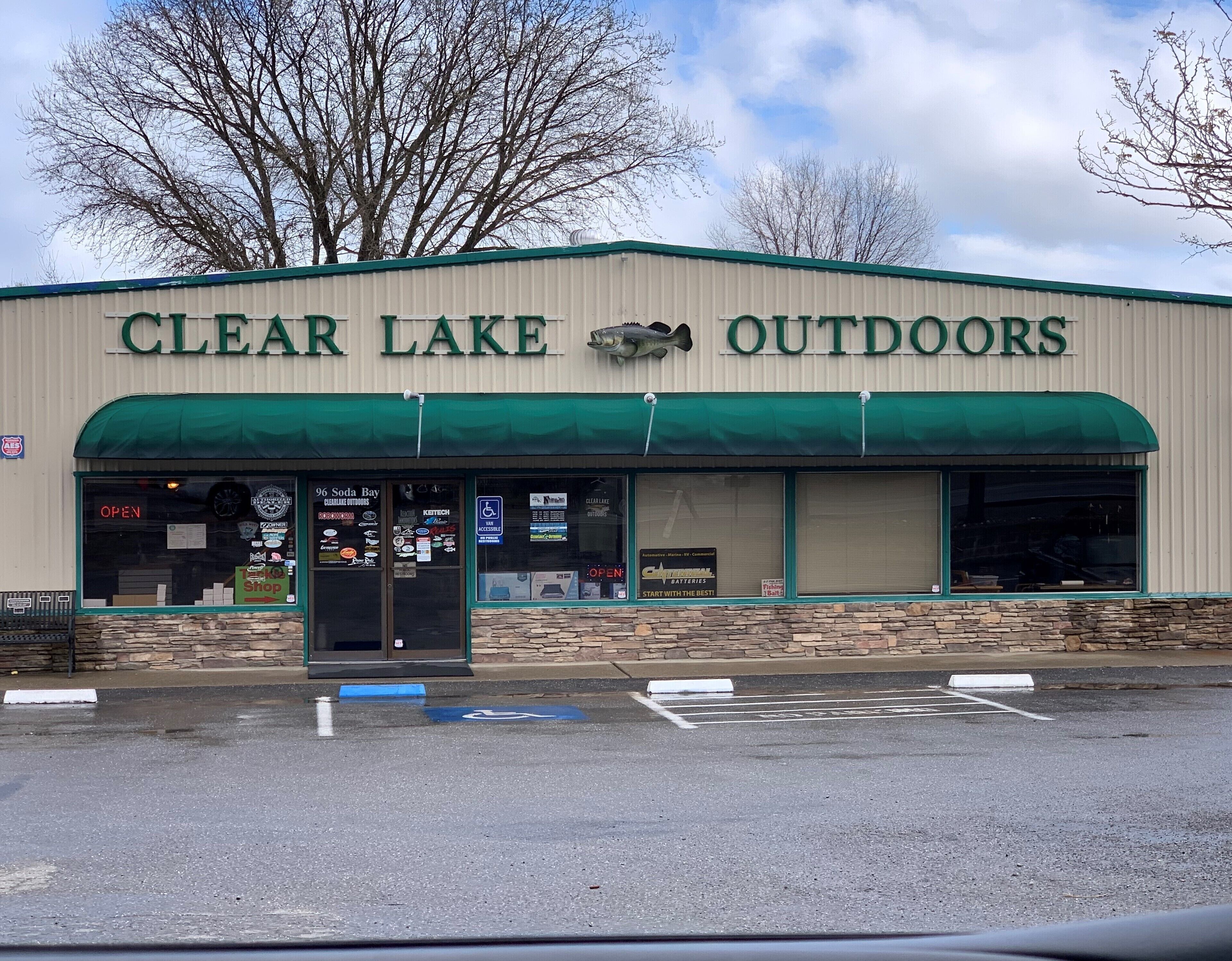 A building with a sign reading 'CLEAR LAKE OUTDOORS' and a fish mounted above the entrance.
