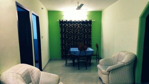 A room with two armchairs, a dining table with chairs, and a curtain. - Noise free home stay (Eranakulam)