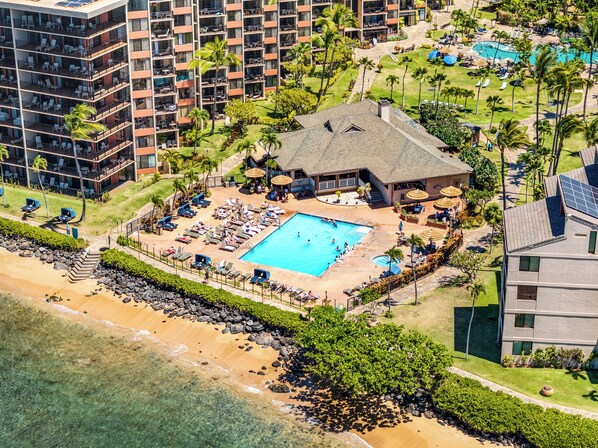 A resort with a swimming pool, beach, and multiple buildings.