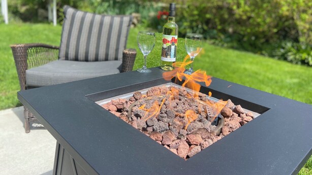 A patio with a black fire pit table, two glasses, and a bottle of wine. - The Lily Pad - quaint home in Old Town NOTL, steps from the lake! (Niagara-on-the-Lake)