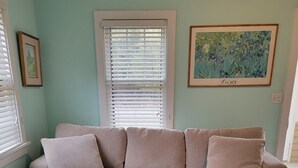 Ein Wohnzimmer mit einer Eckcouch, einem Couchtisch und einem Gemälde an der Wand.
