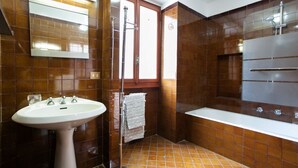 Un bagno con lavabo su piedistallo, vasca da bagno e doccia.
