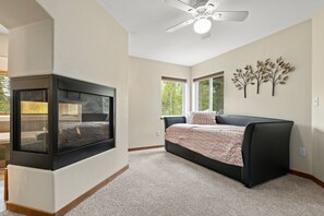 Relax in this serene bedroom with a large bed, flat-screen TV, and ceiling fan.