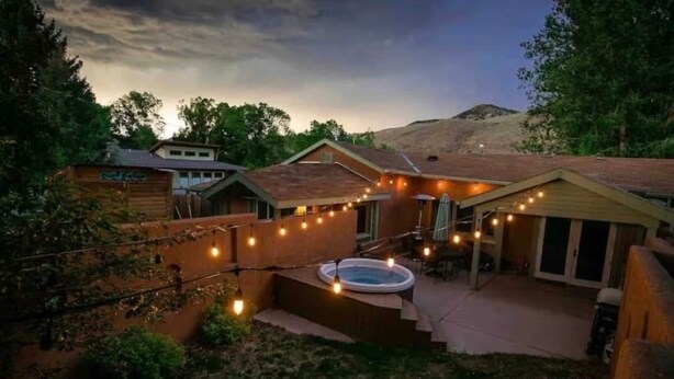 A backyard with a hot tub, string lights, and a wooden deck. - Frontside Hacienda downtown Salida. STR #012962 (Salida)