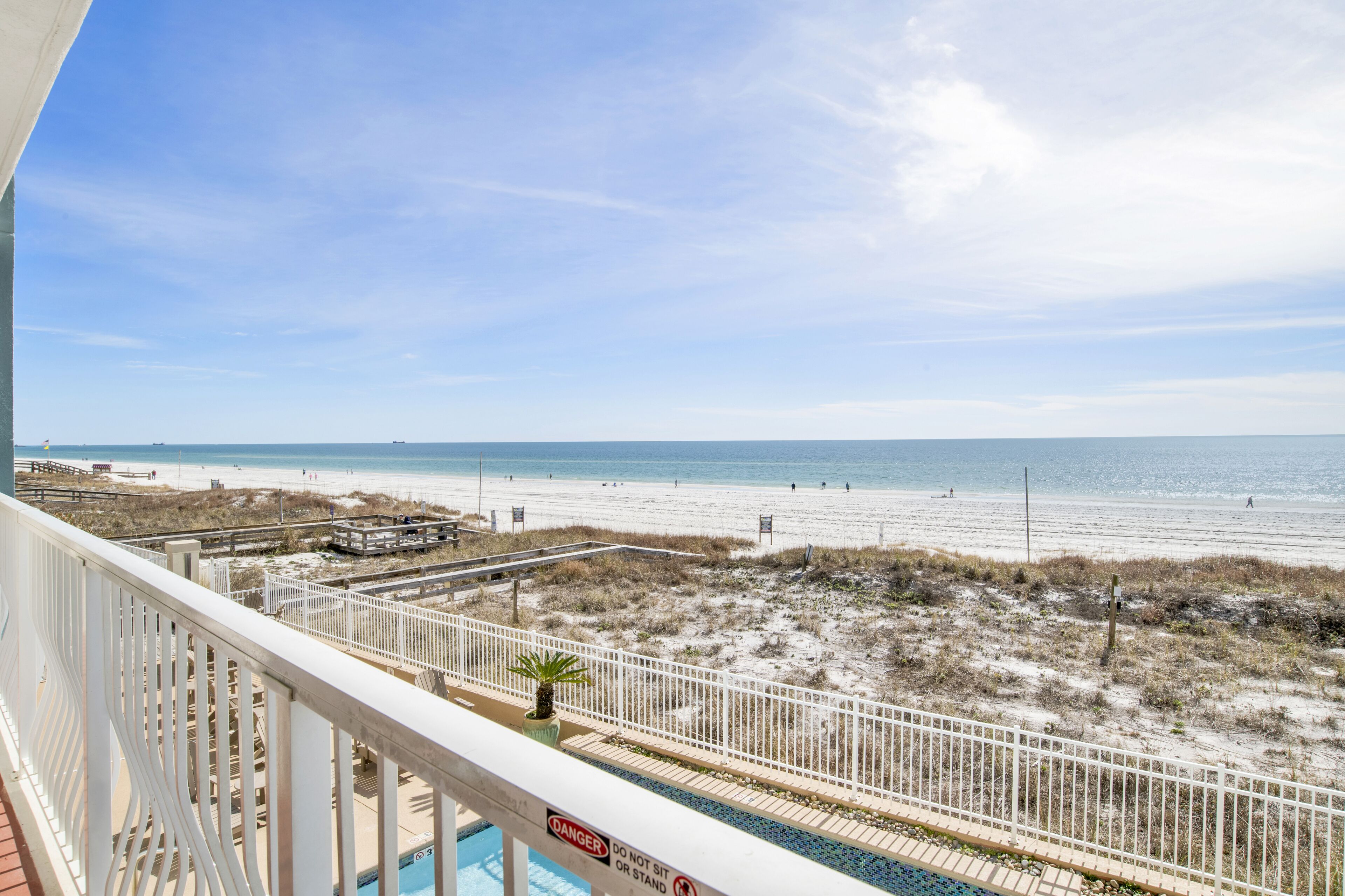 A balcony with a view of a beach and ocean.