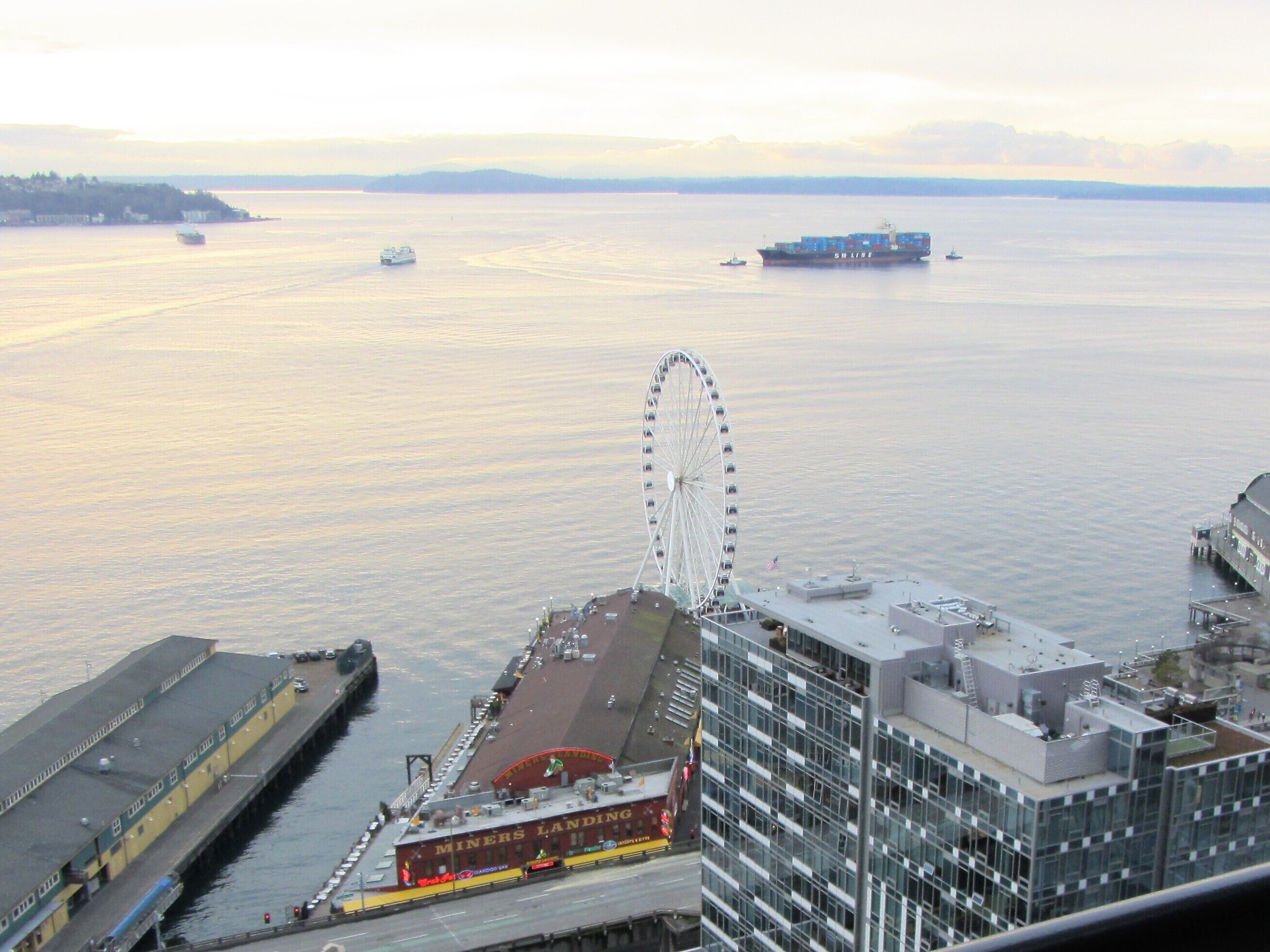 A waterfront view with a large Ferris wheel, a ship, and a building labeled "Miners Landing".
