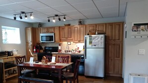 A kitchen with wooden cabinets, a microwave, stove, refrigerator, and a dining table with chairs. - Reduced 50%on30+daysBchMTN/2BR/2BthNew/Clean/Comfort/sleeps4/Wifi/Cable/2mi2rsrt (Beech Mountain)