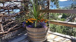 Een houten plantenbak met bloemen op een balkon met uitzicht op een mooi landschap.