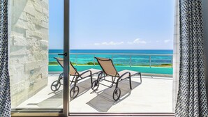 A balcony with two chairs and a bicycle, overlooking a turquoise sea and clear sky. - Casa Flor de Mayo  5BR Villa with Infinity Pool & Stunning Ocean Views (Isla Mujeres)