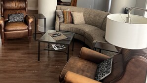 A modern living room with a leather armchair, a sofa, and a coffee table. - Beautiful Downtown Executive Suite (Edmonton)