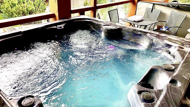 Un jacuzzi con muelle de madera y sillas.
