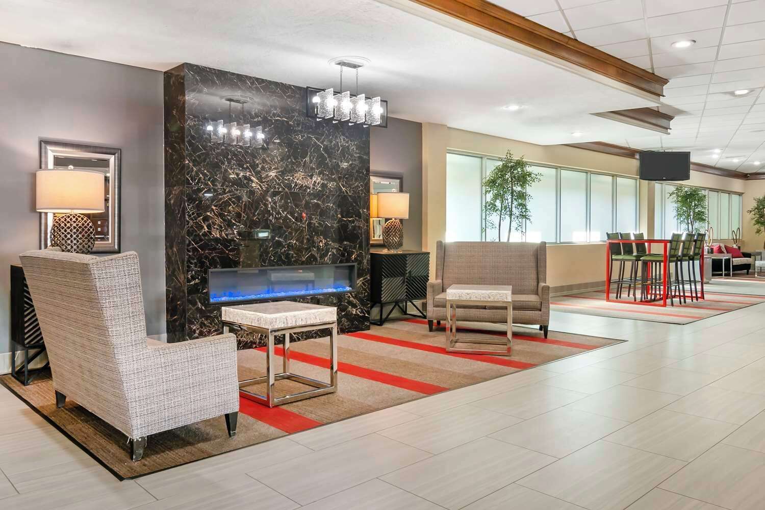 A modern lobby with seating, a large aquarium, and a television.