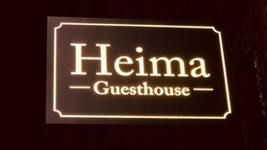 A sign for "Heima Guesthouse" with illuminated lettering. - Heima Guesthouse Hongdae (Seoul)