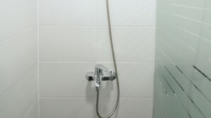 A shower with a handheld showerhead and a wall-mounted control valve. - Heima Guesthouse Hongdae (Seoul)