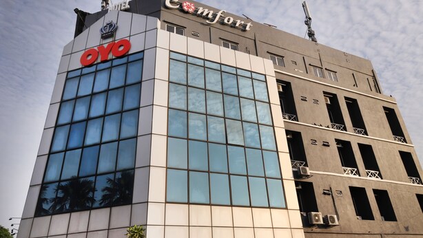 A hotel building with a modern glass facade, a visible logo, and a sign indicating it is a Comfort hotel.