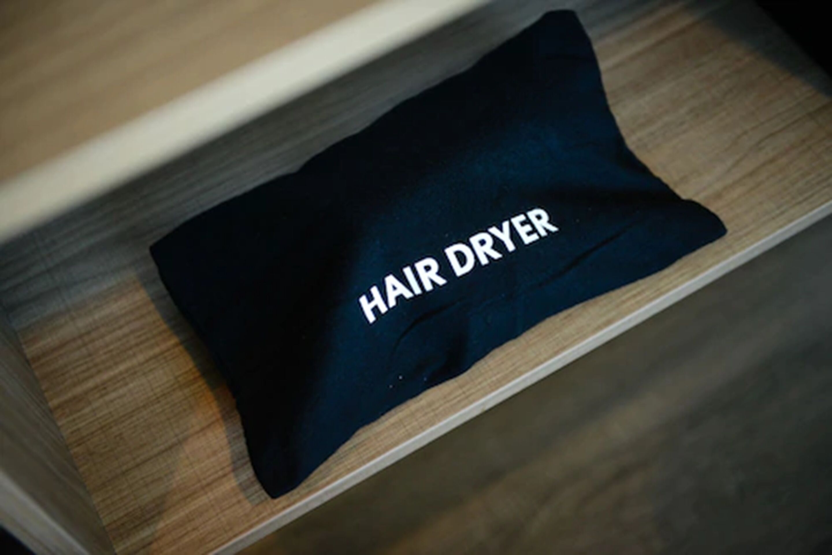 A drawer with a black pouch labeled "HAIR DRYER".