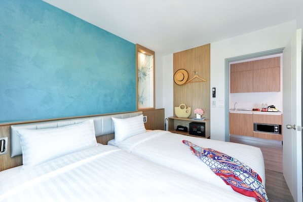 A modern hotel room with a large bed, a small kitchenette, and a bathroom visible through an open door. - Centre Point Prime Hotel Pattaya (Pattaya)