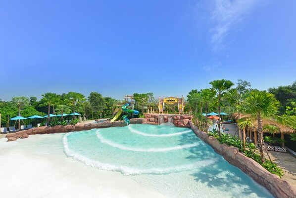 A water park with a wave pool, lounge chairs, and palm trees. - Centre Point Prime Hotel Pattaya (Pattaya)