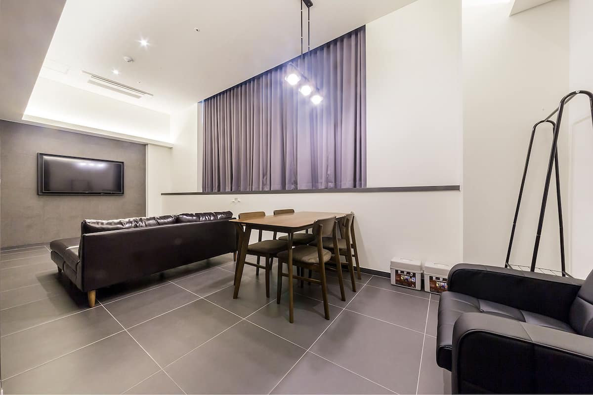 A modern living room with a sofa, dining table, and chairs.