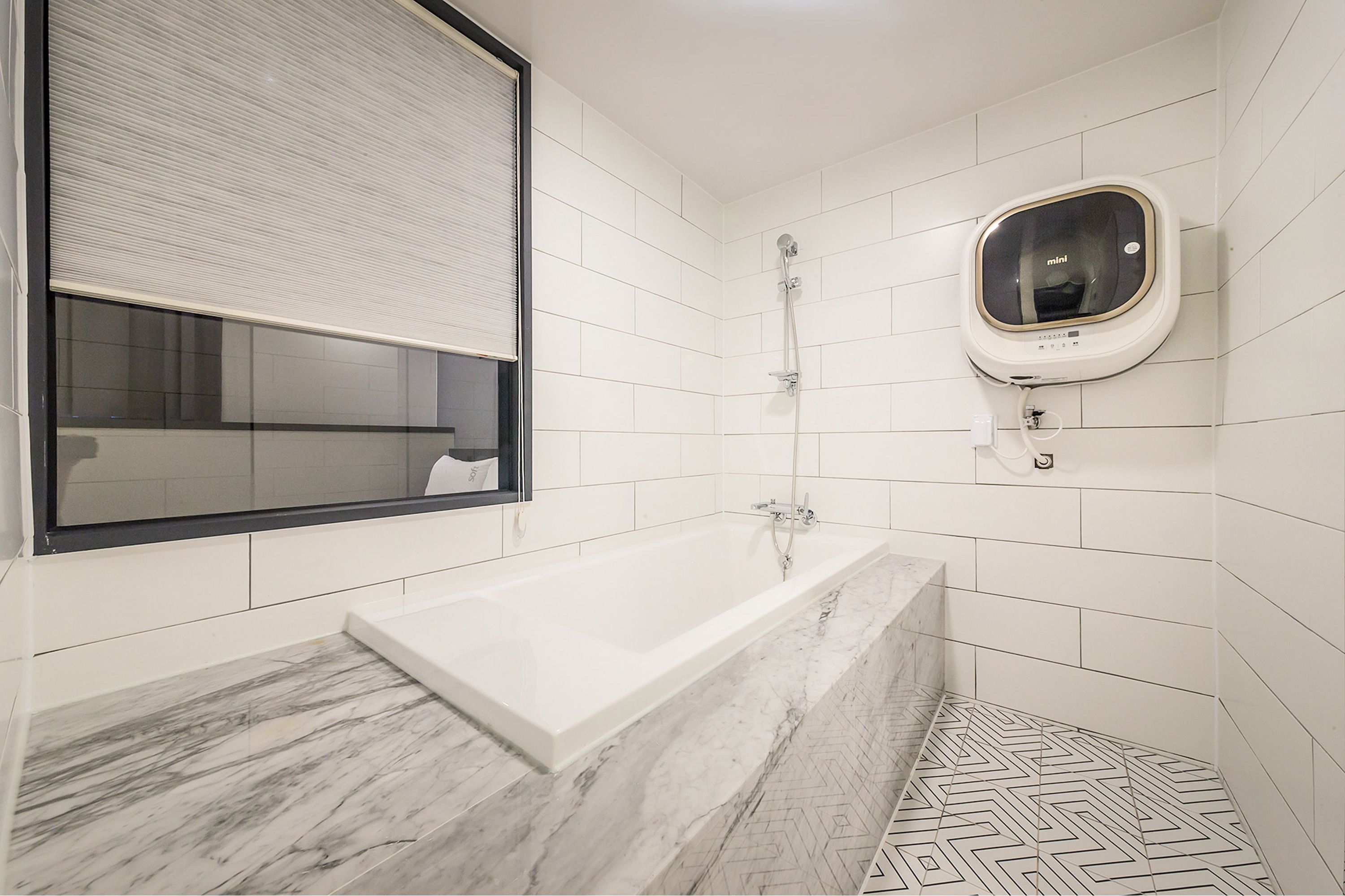 A bathroom with a bathtub, a mirror, and a toilet.