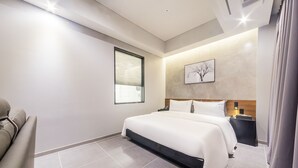A modern hotel room with a large bed, a bedside table, a chair, and a window. - Pyeongtaek Stay Hotel (Pyeongtaek)