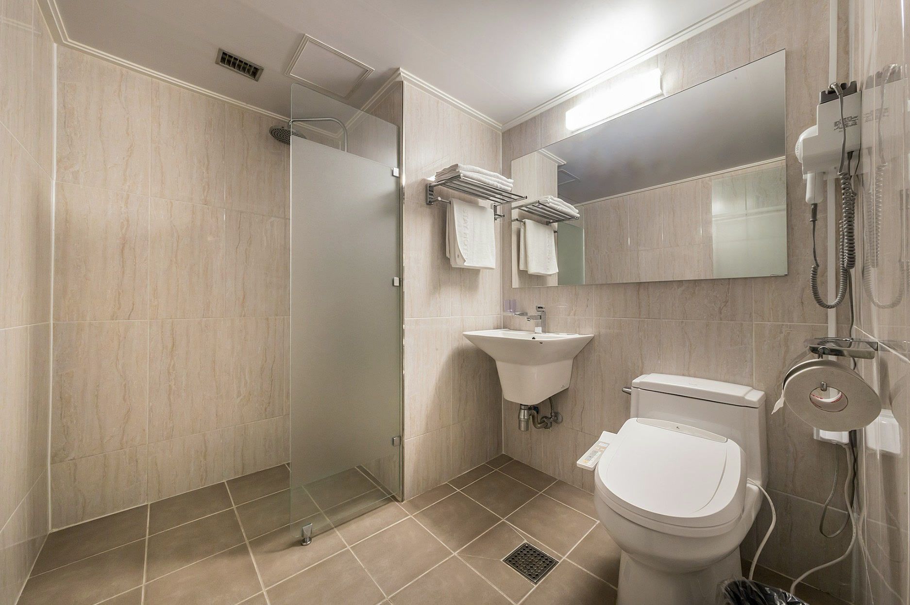 A modern bathroom with a glass-enclosed shower, a sink, and a toilet.