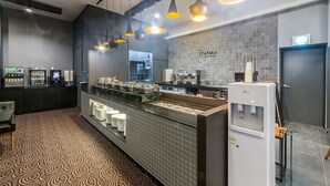 A modern cafe with a counter, coffee machines, and a water dispenser. - Pyeongtaek Stay Hotel (Pyeongtaek)