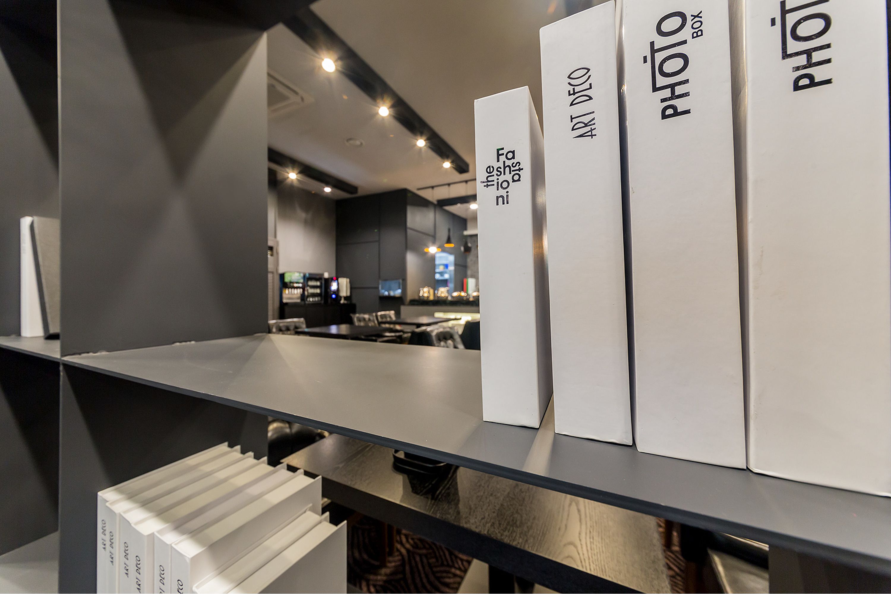 A modern interior with a glass partition and a counter displaying photo boxes.